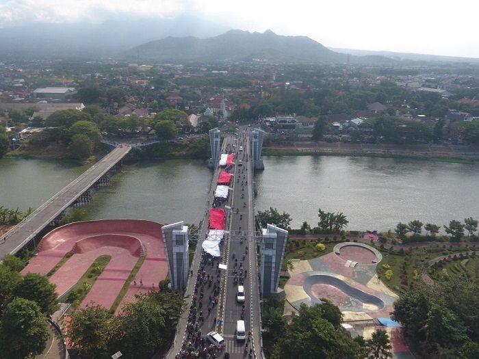 Ratusan Pemuda Kota Kediri Arak Bendera Merah Putih Raksasa untuk Dikibarkan di Atas Gunung