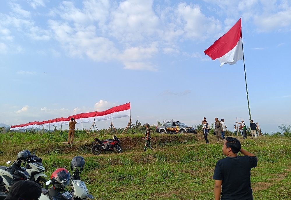 Bentuk Rasa Cinta Tanah Air, Warga Kibarkan Bendera Raksasa dan Kain Sepanjang 100 Meter di Bukit Lahan Pemkab Jember