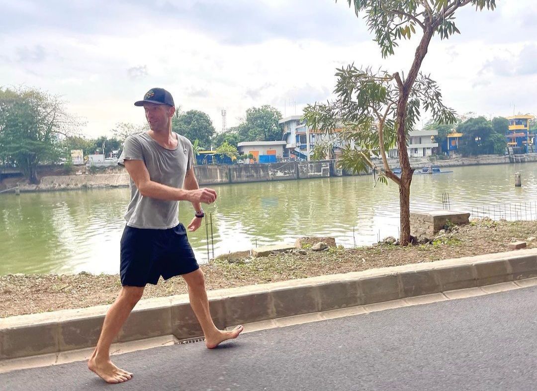 Viral Chris Martin Santai Kaosan dan Nyeker di Sudirman, Netizen: Enak Sambil Makan Cilor